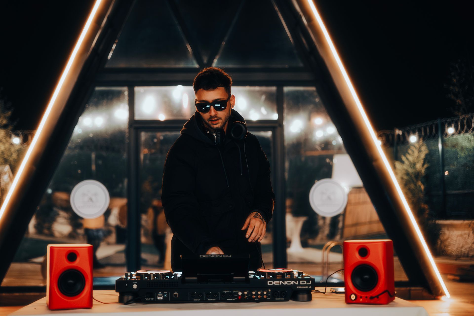 DJ za miks-pultom na večernjem događaju sa scenskom rasvjetom